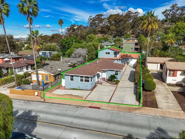 an aerial view of multiple houses with a street