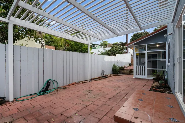 an empty room with wooden floor chandelier fan and windows