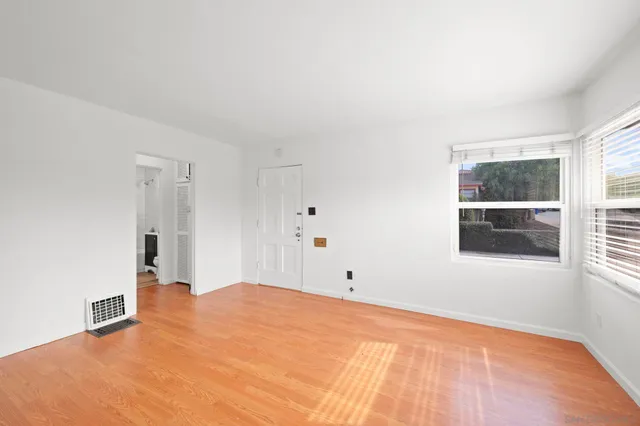 an empty room with windows and closet