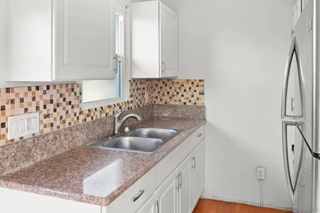 an empty room with wooden floor closet and fan