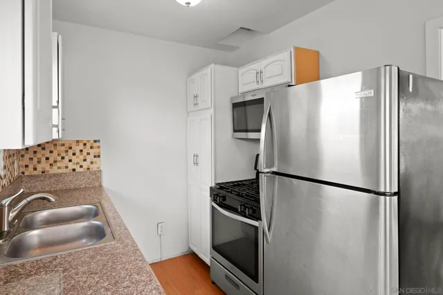 a view of empty room with wooden floor and ceiling fan