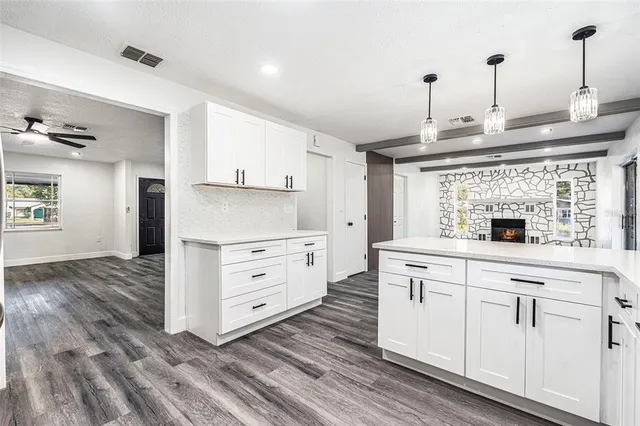 a kitchen with white cabinets and sink