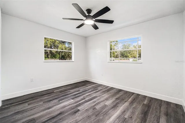 a view of empty room with wooden floor