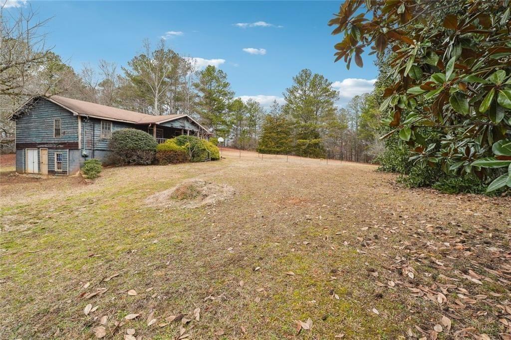 8265 Seabolt Drive Ball Ground, GA 30107 - Photo 16 of 52 a yellow house with trees in front of it