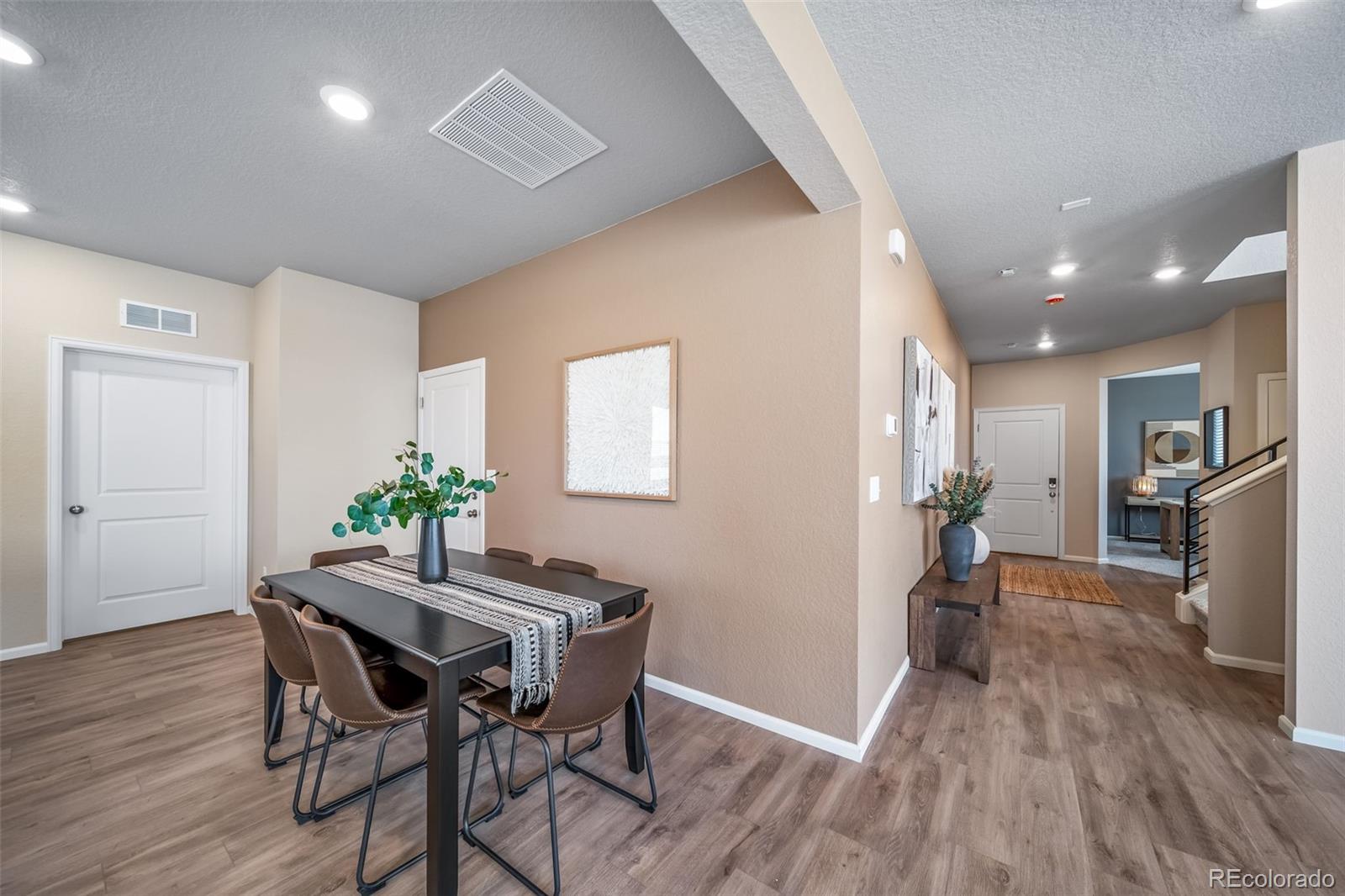 10155 Scranton Way Commerce City, CO 80022 - Photo 15 of 28 a view of a dining room with furniture and wooden floor