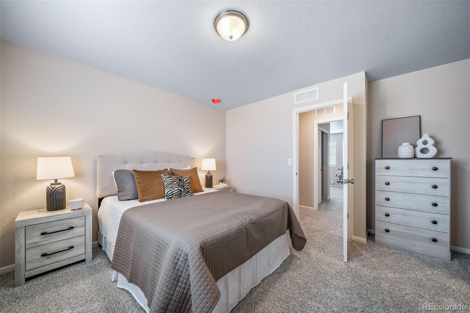 10155 Scranton Way Commerce City, CO 80022 - Photo 16 of 28 a bedroom with a bed and a dresser