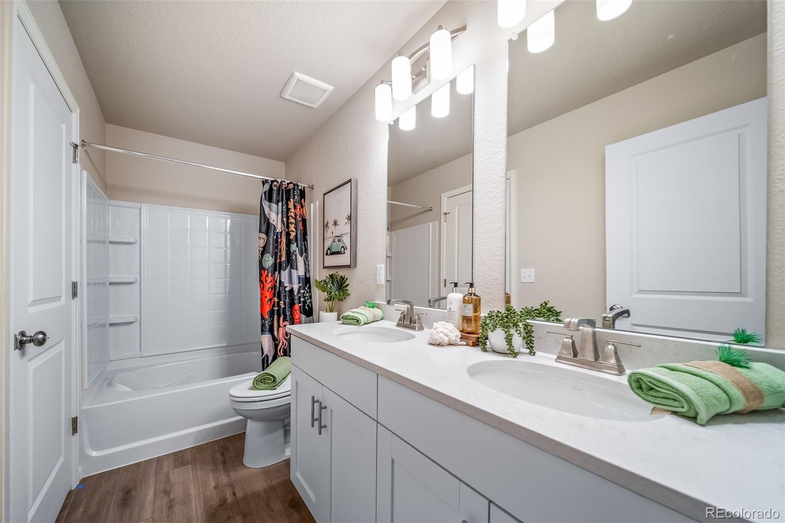 10155 Scranton Way Commerce City, CO 80022 - Photo 19 of 28 a bathroom with a double vanity sink toilet and shower