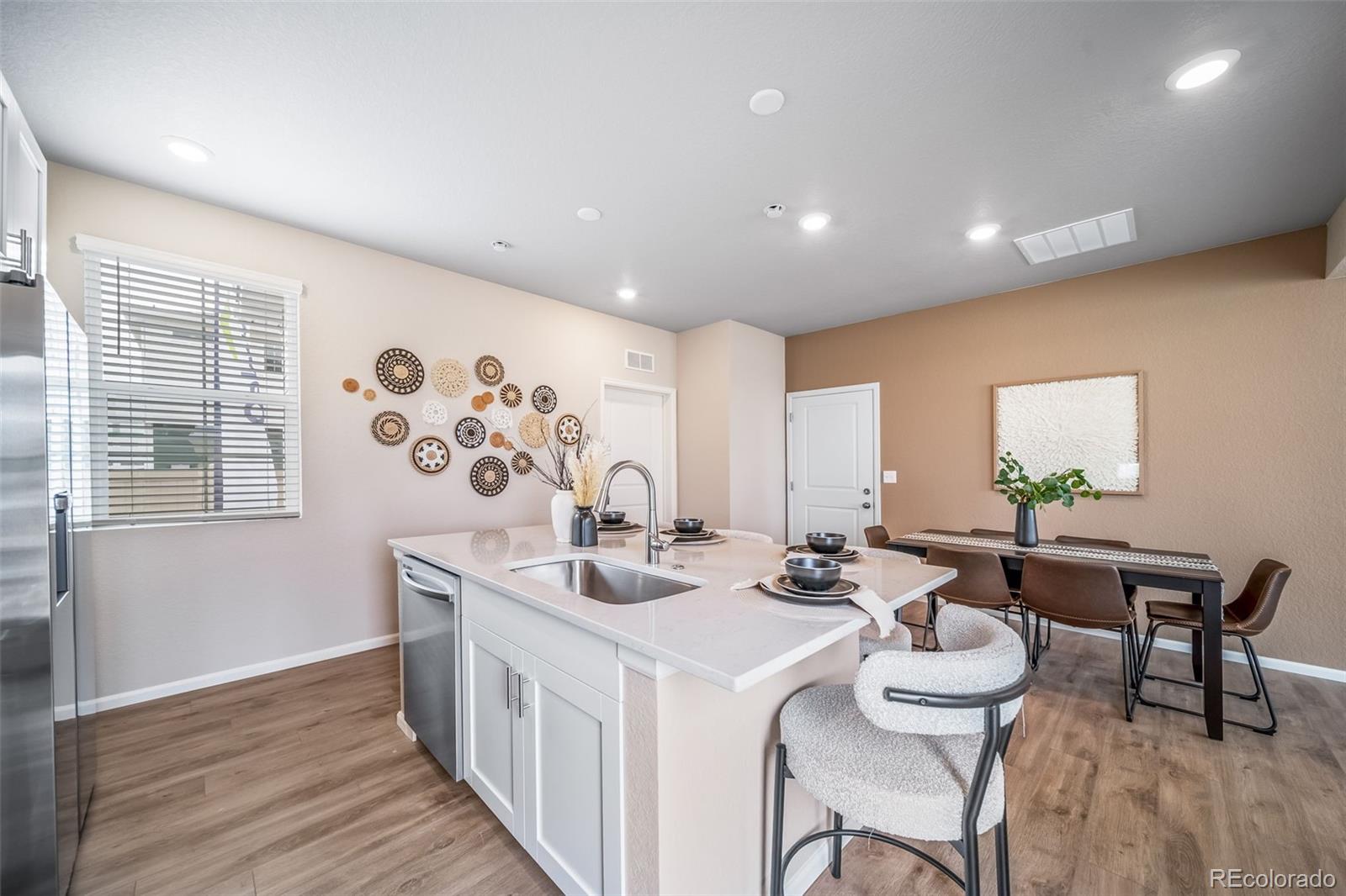 10155 Scranton Way Commerce City, CO 80022 - Photo 3 of 28 a view of a dining room with furniture window and wooden floor