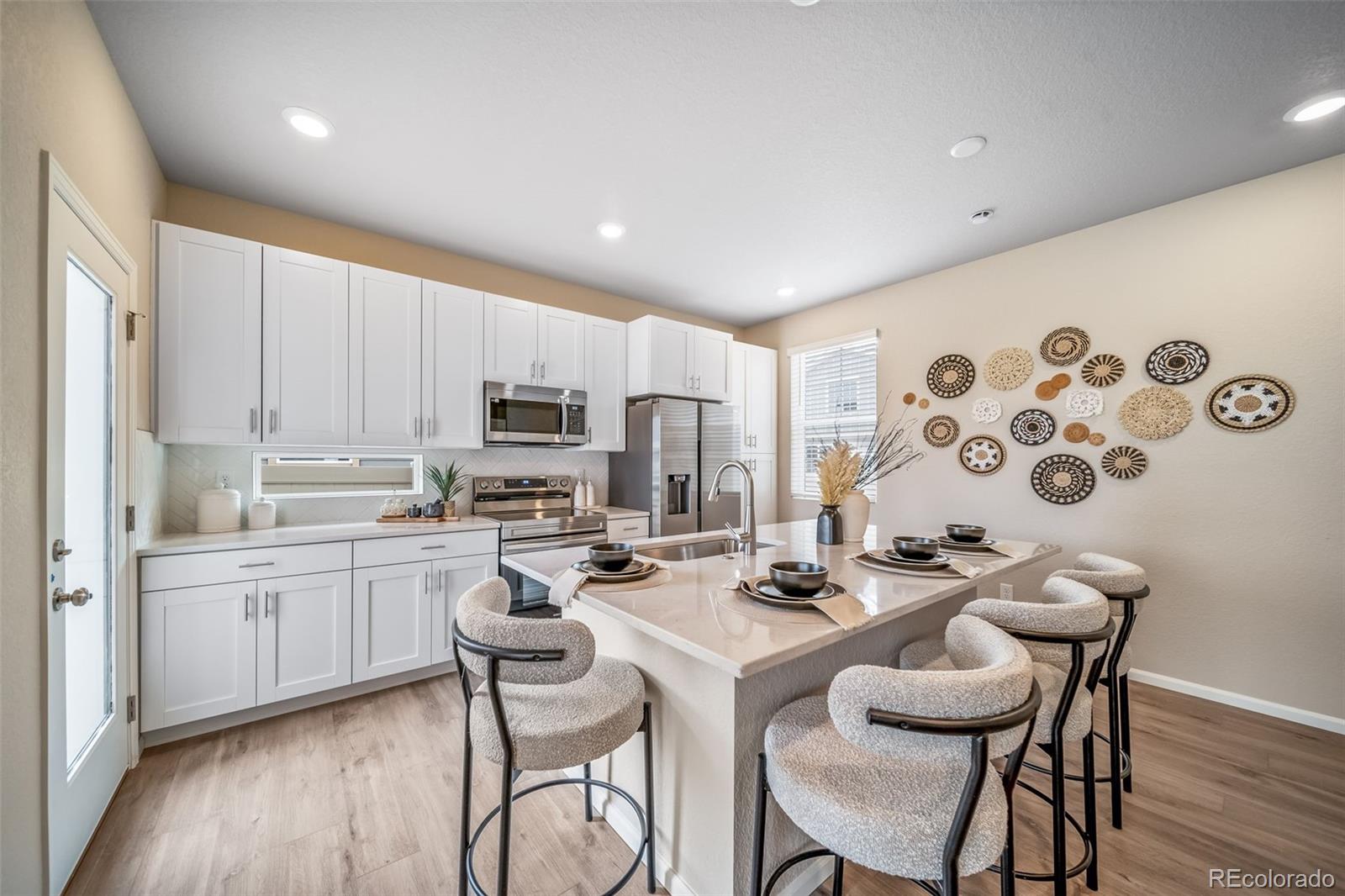 10155 Scranton Way Commerce City, CO 80022 - Photo 5 of 28 a kitchen with a dining table chairs sink and microwave