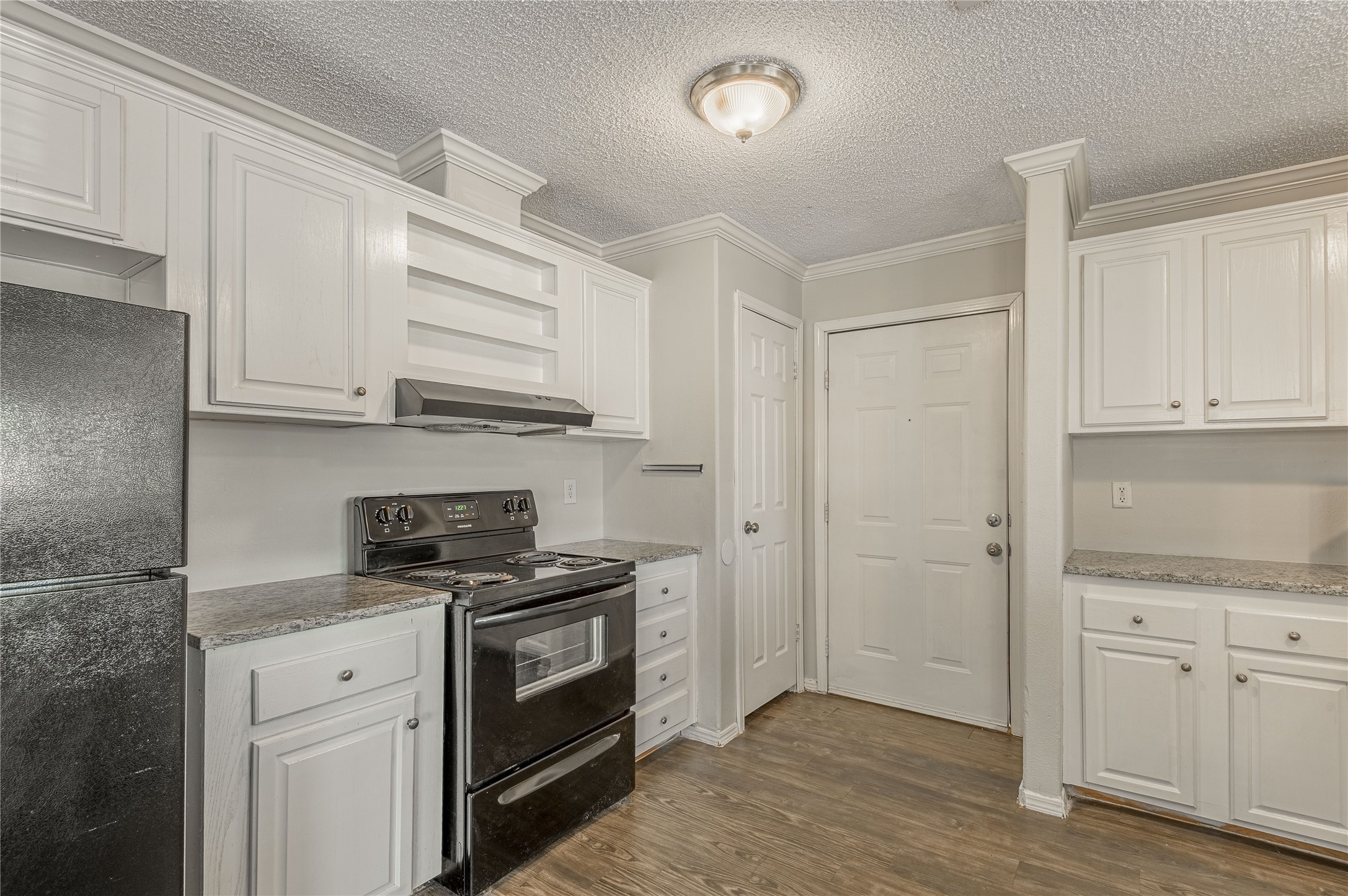 138 Varsity Circle Huntsville, TX 77340 - Photo 11 of 37 a kitchen with stainless steel appliances white cabinets and a stove top oven