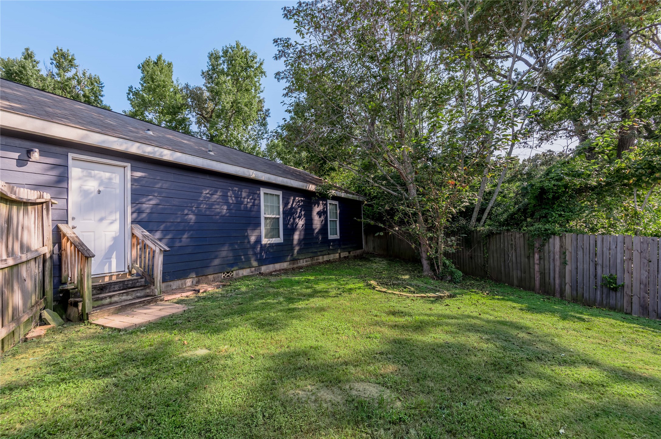 138 Varsity Circle Huntsville, TX 77340 - Photo 33 of 37 a view of a backyard with a large tree and wooden fence
