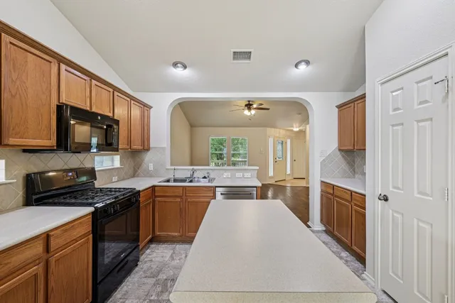a large kitchen with stainless steel appliances granite countertop a stove sink and cabinets