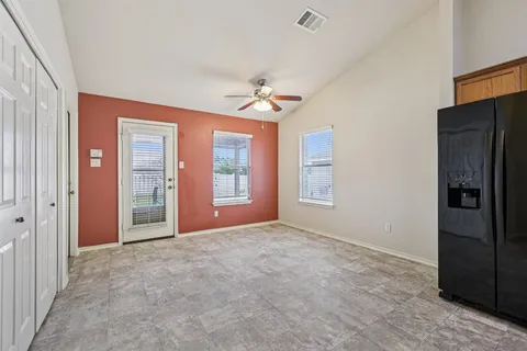 an empty room with closet and windows