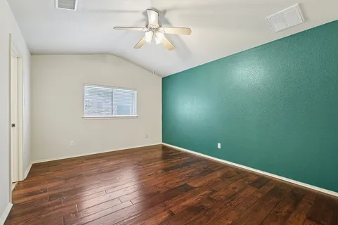 a view of a big room with wooden floor and windows