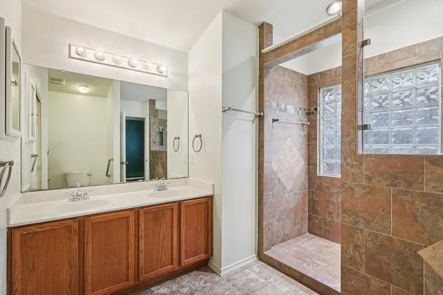 a bathroom with a double vanity sink mirror and shower