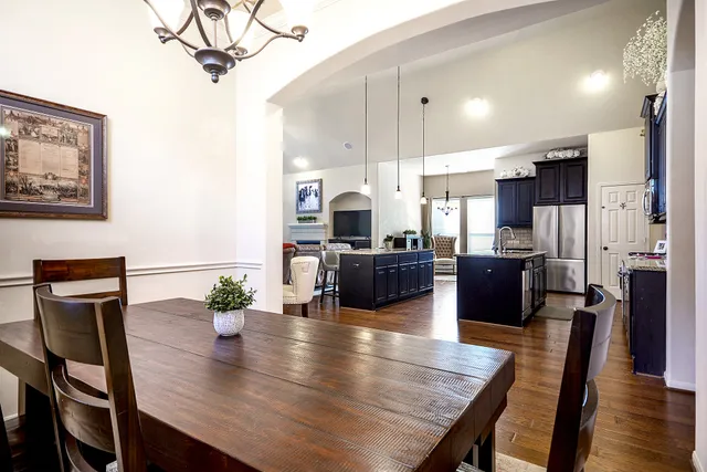 a kitchen with a table chairs refrigerator and microwave