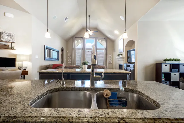 a kitchen with stainless steel appliances granite countertop a sink a stove and a refrigerator