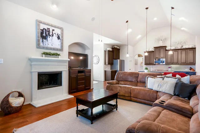 a living room with furniture kitchen and a wooden floor