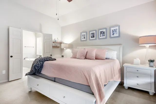 a spacious bedroom with a large bed and a chandelier fan