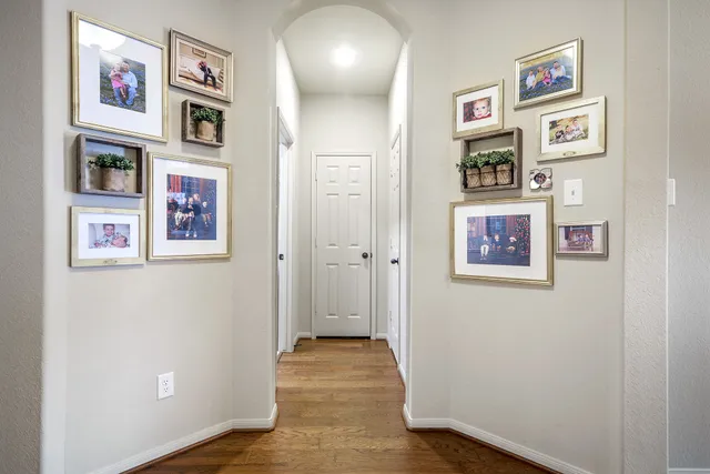 a view of a hallway with wooden floor and workspace