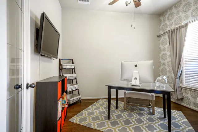 a view of a workspace with furniture and a window