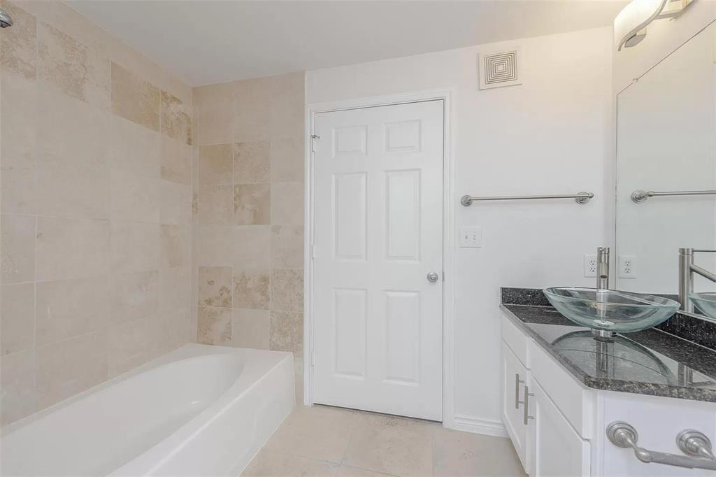 3102 Kings Road, Unit 2303 Dallas, TX 75219 - Photo 11 of 23 a bathroom with a granite countertop sink a mirror and a bathtub