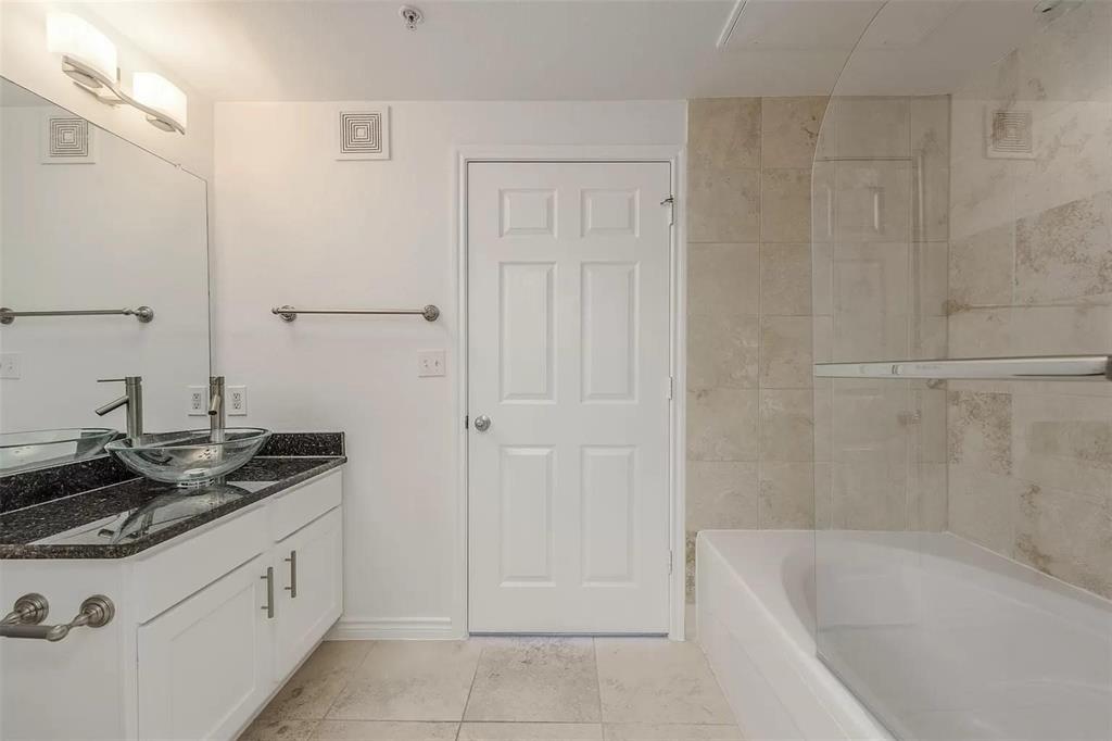 3102 Kings Road, Unit 2303 Dallas, TX 75219 - Photo 10 of 23 a bathroom with a granite countertop sink a toilet and bathtub