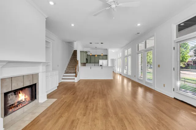 a view of a room with wooden floor fireplace and windows