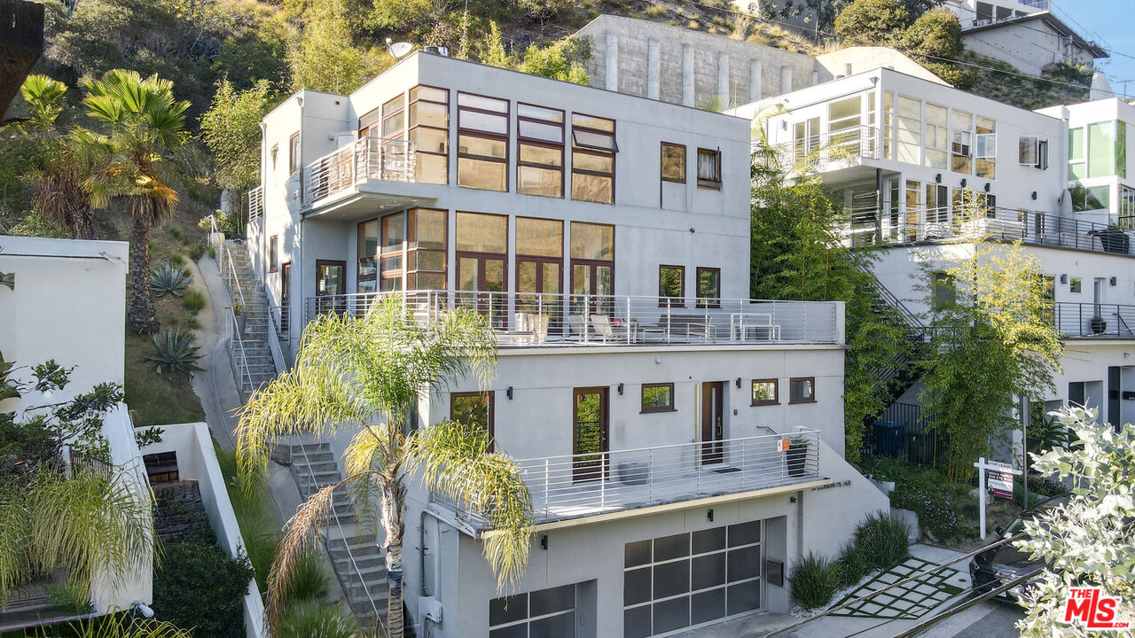 a front view of a building with balcony and outdoor seating