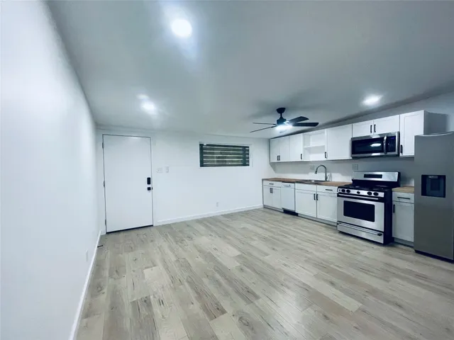 a kitchen with stainless steel appliances a cabinets and wooden floor