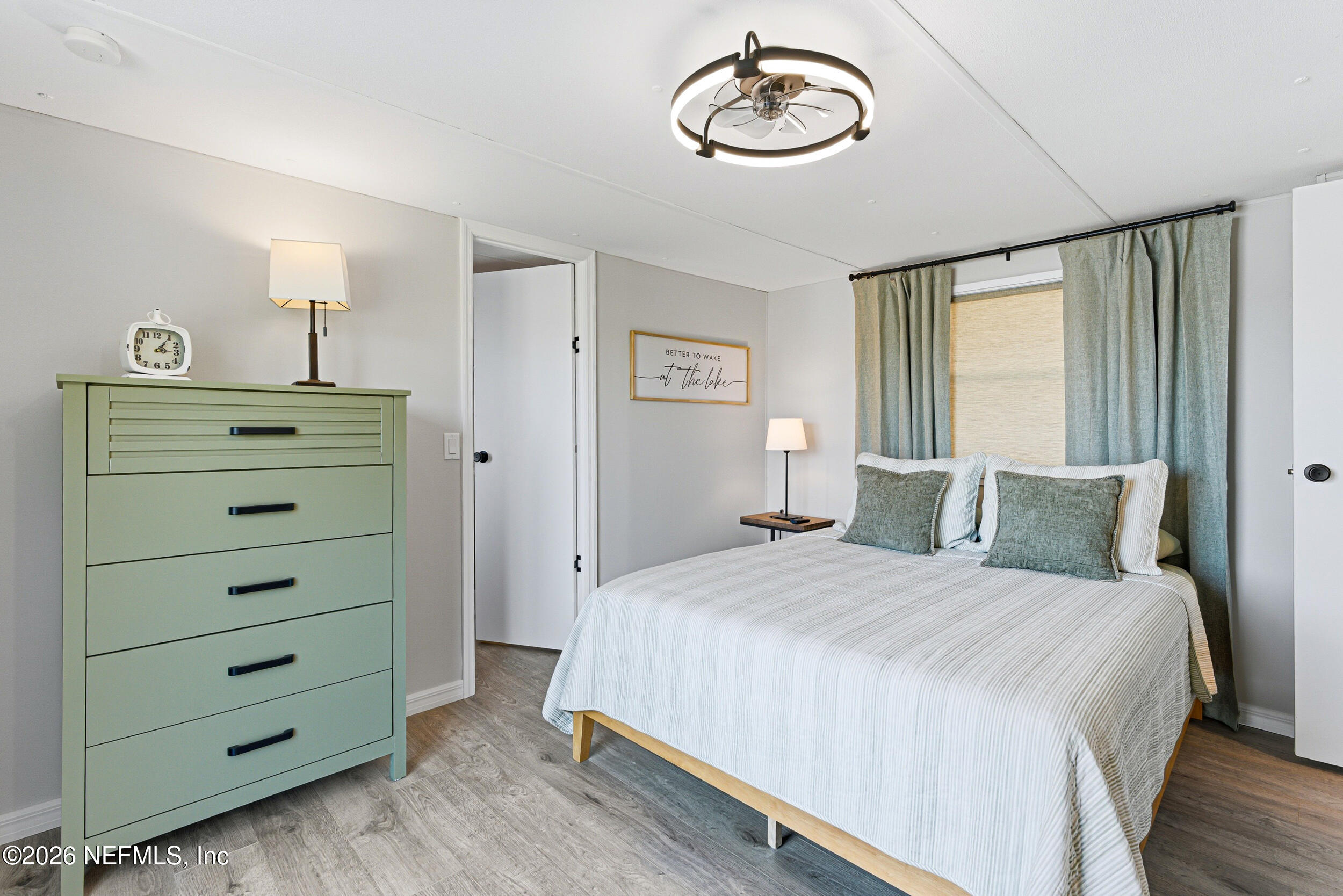 115 Lake Susan Road Hawthorne, FL 32640 - Photo 15 of 62 a bedroom with a bed and a chandelier
