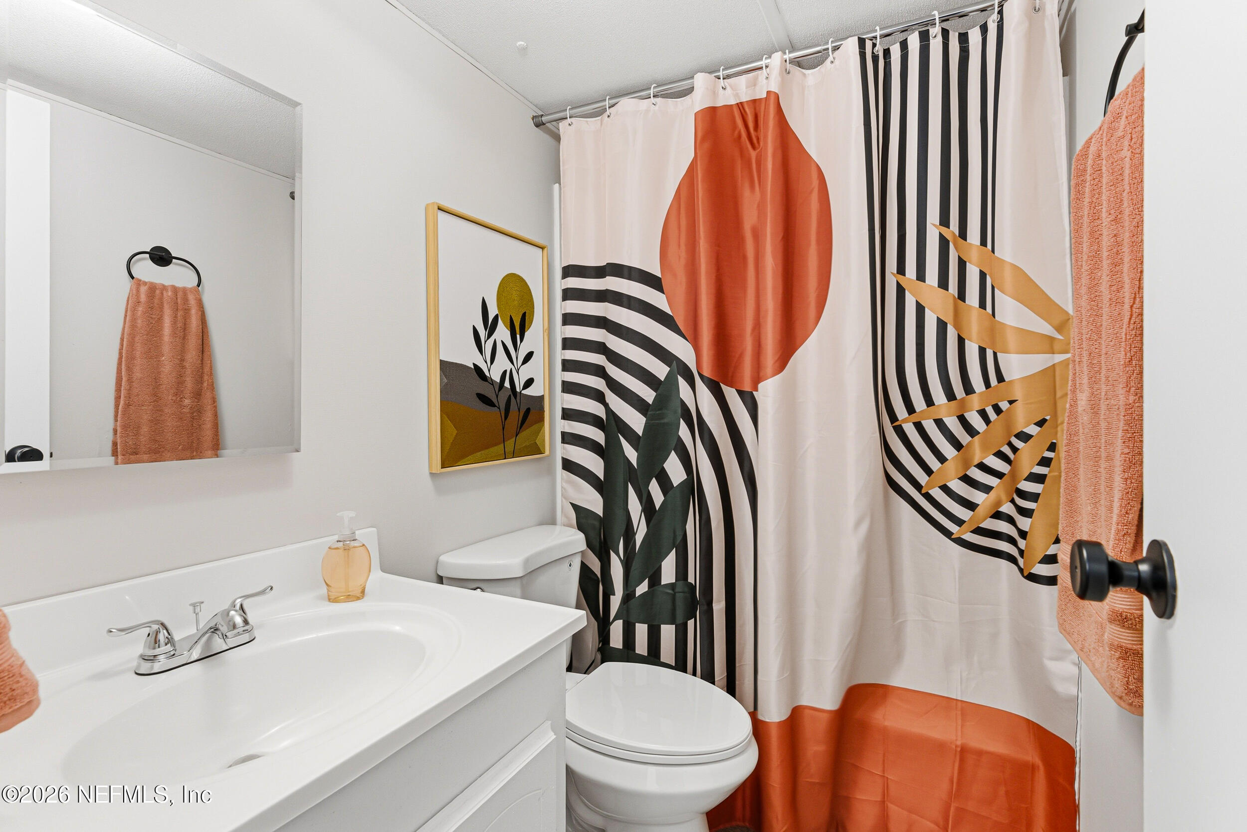 115 Lake Susan Road Hawthorne, FL 32640 - Photo 22 of 62 a bathroom with a sink a toilet and shower curtain