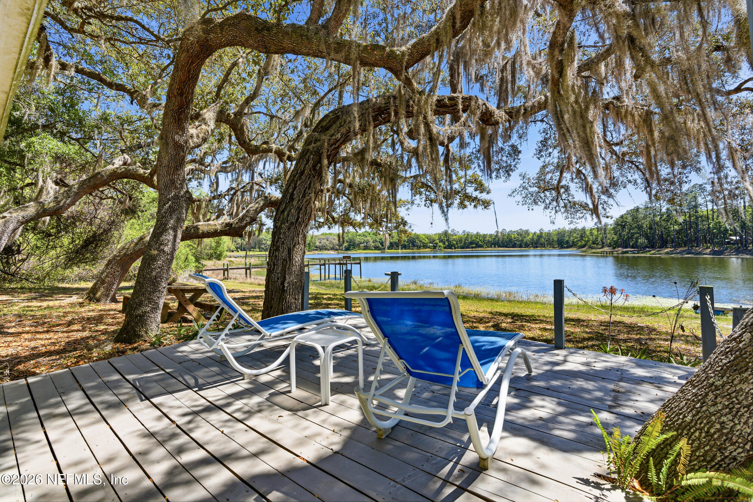 115 Lake Susan Road Hawthorne, FL 32640 - Photo 36 of 62 a view of a lake with couches and table and chairs under an umbrella