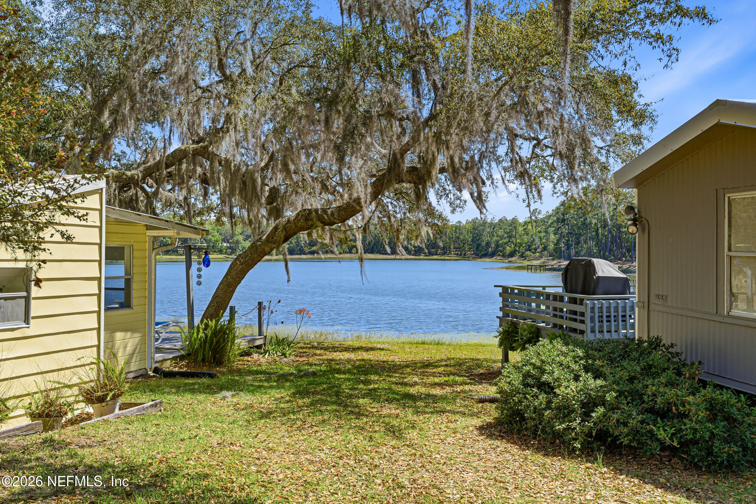 115 Lake Susan Road Hawthorne, FL 32640 - Photo 4 of 62 a view of a backyard with table and chairs and potted plants