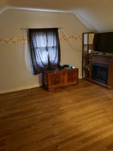 a room with wooden floor and a fireplace