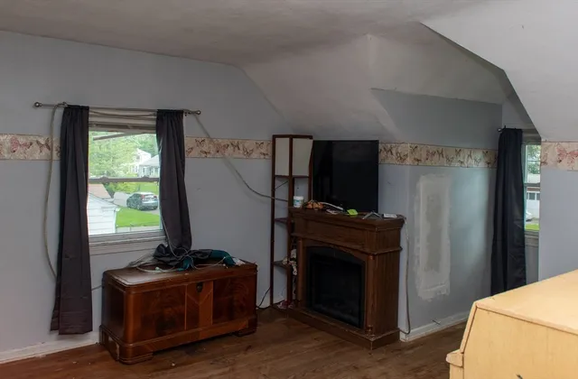 a living room with stainless steel appliances furniture and a fireplace
