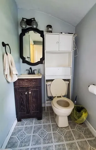 a bathroom with a toilet mirror vanity and a sink