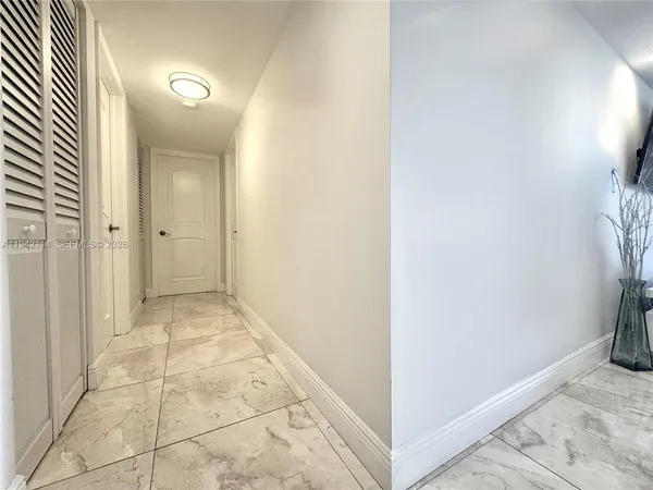 a bed sitting in a bedroom next to a window with a large mirror