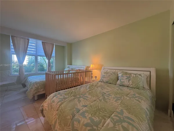 a spacious bedroom with a bed and a television