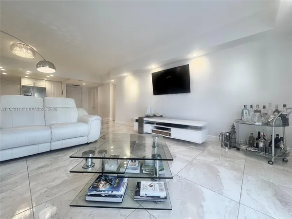 a living room with couches and kitchen view with wooden floor