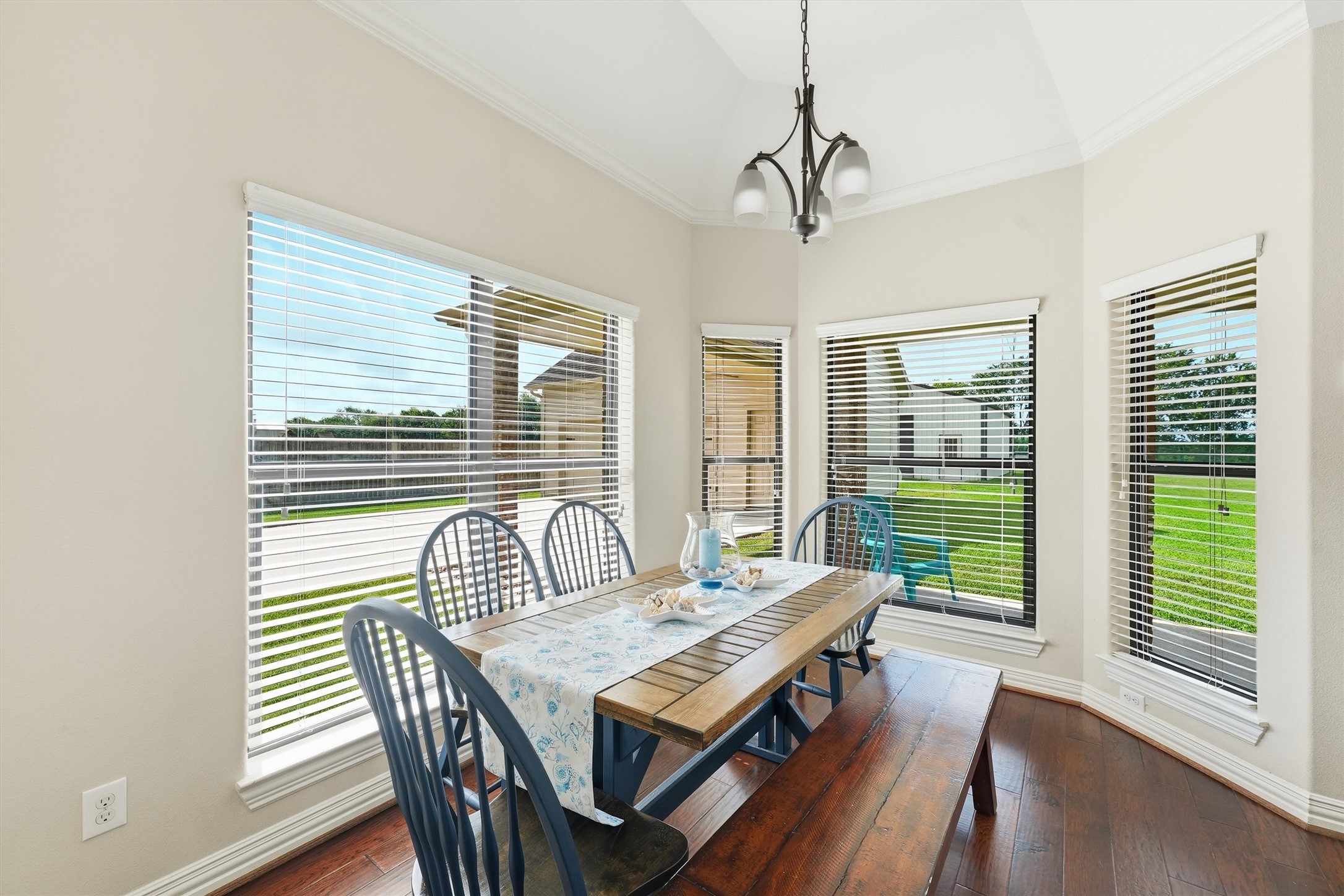 4810 Magnolia Bend Drive Rosharon, TX 77583 - Photo 15 of 40 Bright and inviting breakfast nook with large windows overlooking a lush backyard, featuring a charming wooden table and elegant light fixture.