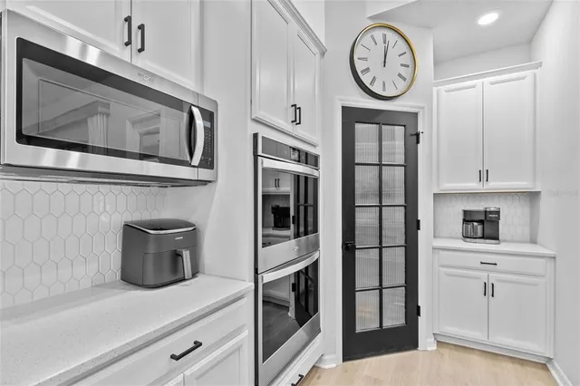 a bedroom with a bed a flat tv screen and two windows