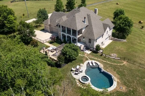 an aerial view of a house with yard swimming pool and outdoor seating