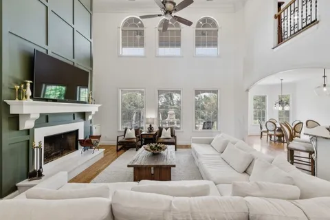 a kitchen with stainless steel appliances a refrigerator a sink a stove and white cabinets with wooden floor