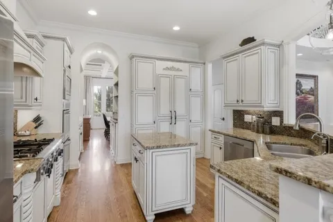 a view of kitchen with white cabinets and refrigerator