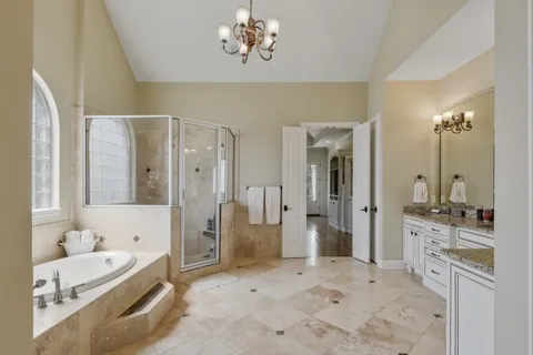 a bathroom with a granite countertop sink toilet mirror vanity and shower