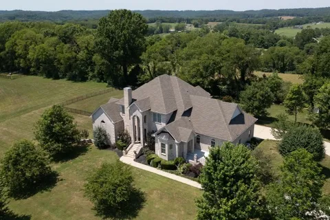 an aerial view of a house with yard and outdoor seating