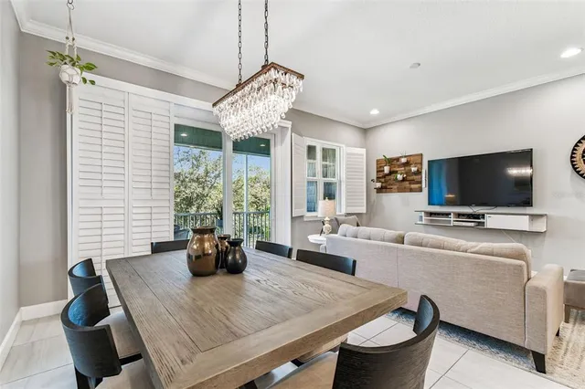a living room with furniture kitchen view and a chandelier