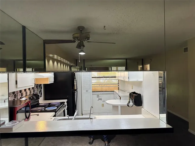 an empty room with closet and a chandelier fan