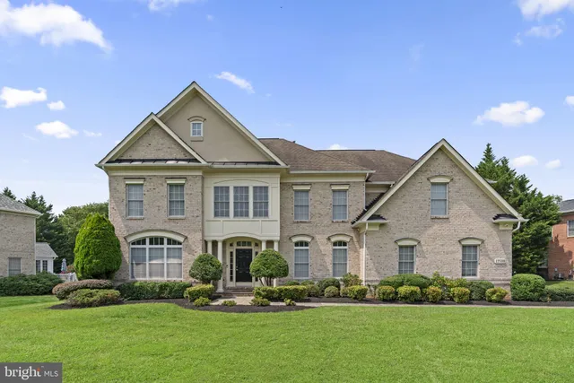 a front view of a house with a yard and trees